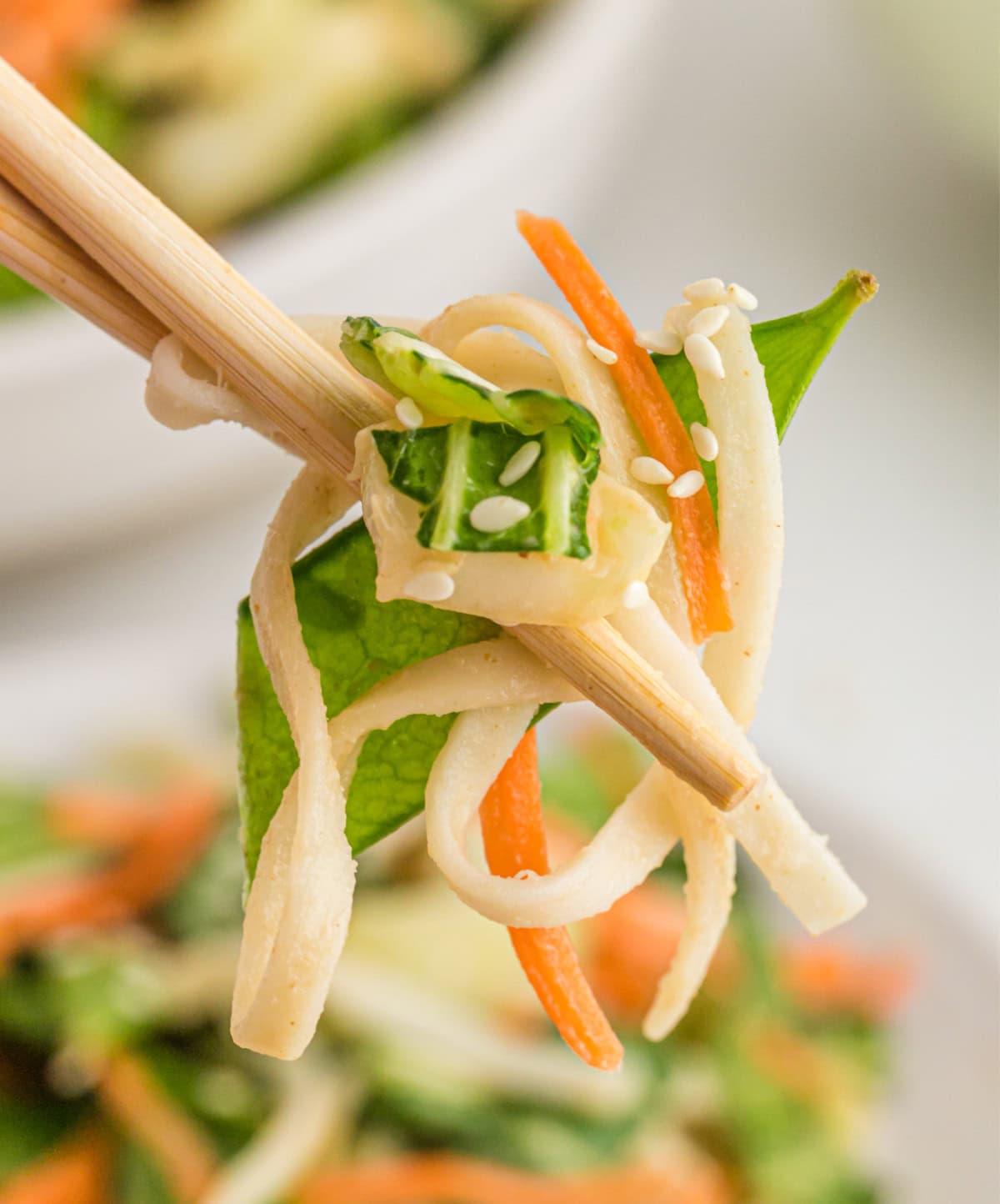 If you love a little heat, these Spicy Peanut Noodles will be your new obsession. A creamy, nutty sauce coats noodles and crunchy veggies — fast, flavorful, and perfect for busy weeknights! chopsticks holding spicy peanut noodles