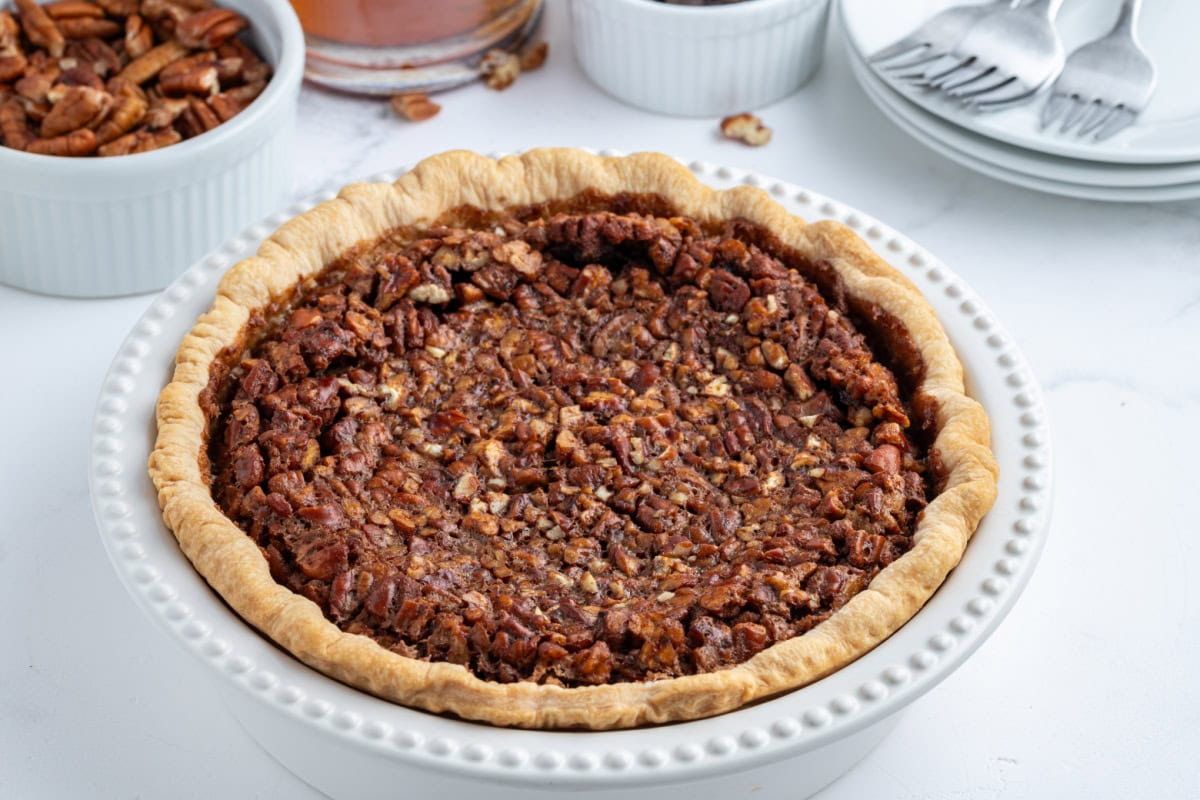 Rich Bourbon Chocolate Pecan Pie made with dark corn syrup, brown sugar, melted chocolate, and toasted pecans. A decadent holiday dessert that’s unforgettable! bourbon chocolate pecan pie