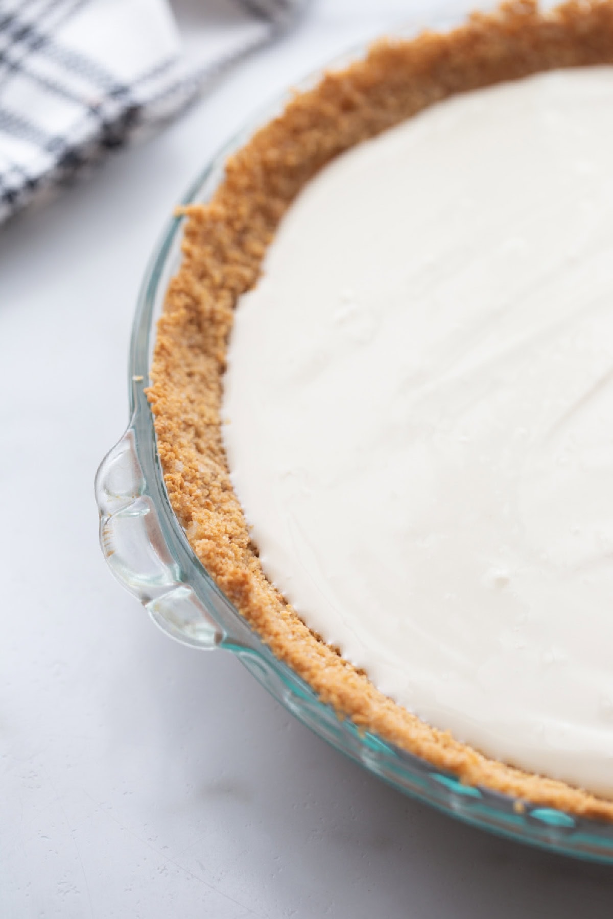 graham cracker crust with cream cheese layer poured into it pie