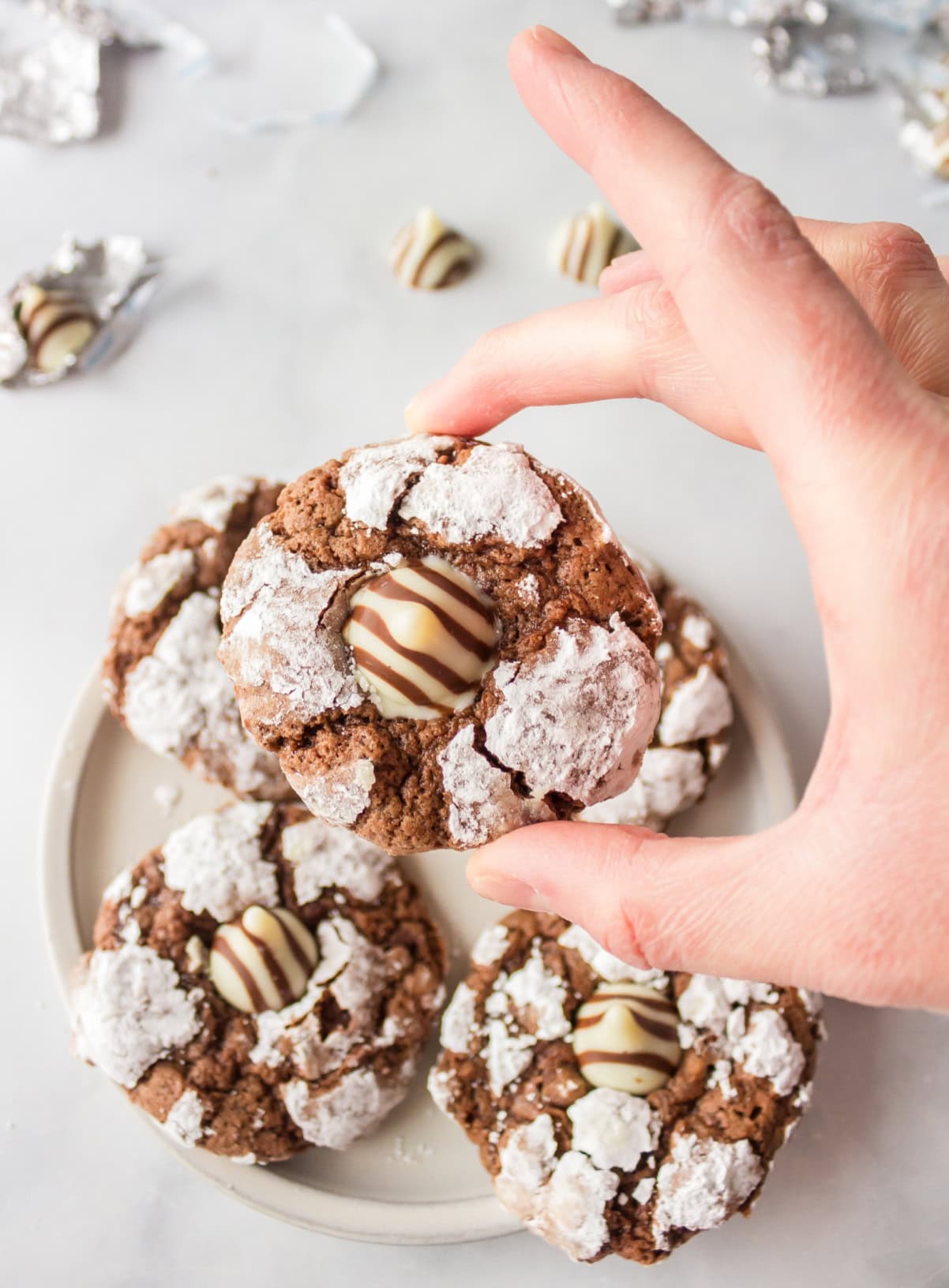 hand holding a chocolate chocolate kiss cookie