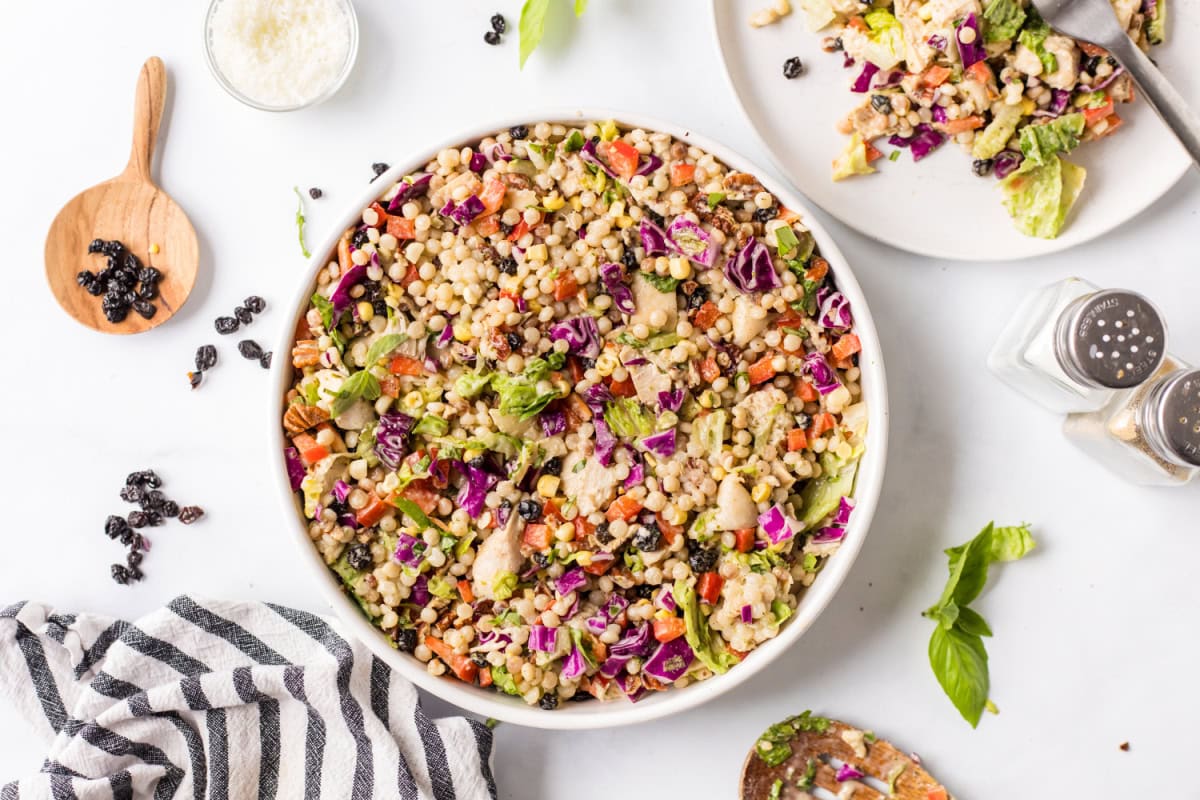 This Chopped Chicken and Couscous Salad with Sweet Basil Dressing is fresh, flavorful, and flexible! Swap turkey, wild rice, and cranberries for a fall twist. bowl of chopped chicken and couscous salad