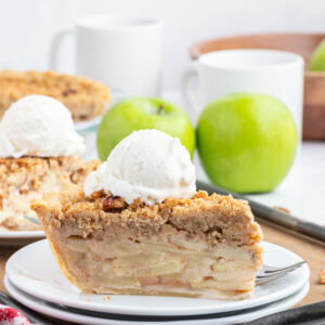 slice of dutch apple pie on plate with scoop of ice cream on top