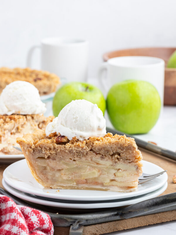 slice of dutch apple pie on plate with scoop of ice cream on top