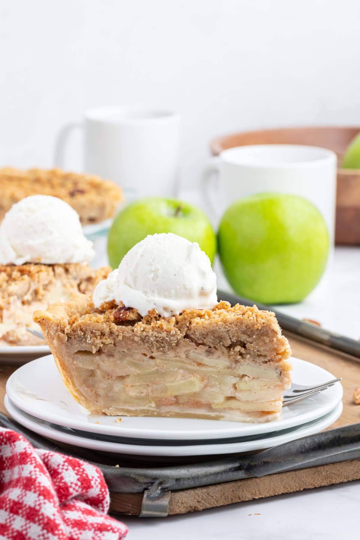 Homemade Dutch Apple Pie with buttery pecan streusel and cinnamon apples. Cozy, classic, and perfect for fall baking or holiday dessert tables. slice of dutch apple pie on plate with scoop of ice cream on top