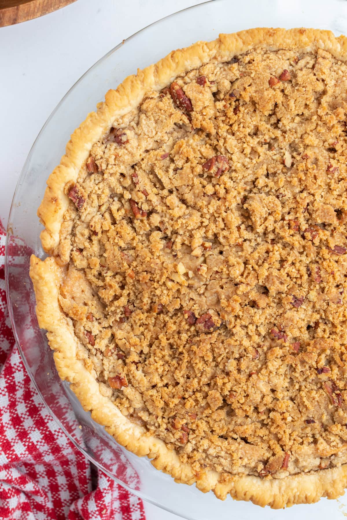 Homemade Dutch Apple Pie with buttery pecan streusel and cinnamon apples. Cozy, classic, and perfect for fall baking or holiday dessert tables. shot of half of a dutch apple pie