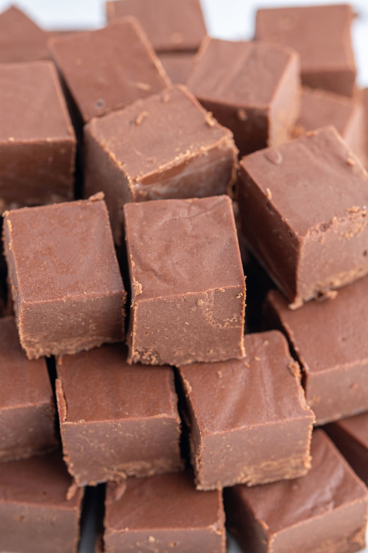 This Easy Microwave Kahlua Fudge has two chocolate layers, a rich Kahlua coffee flavor, and comes together in minutes. Perfect for holiday gifts and dessert trays! lots of kahlua fudge pieces stacked