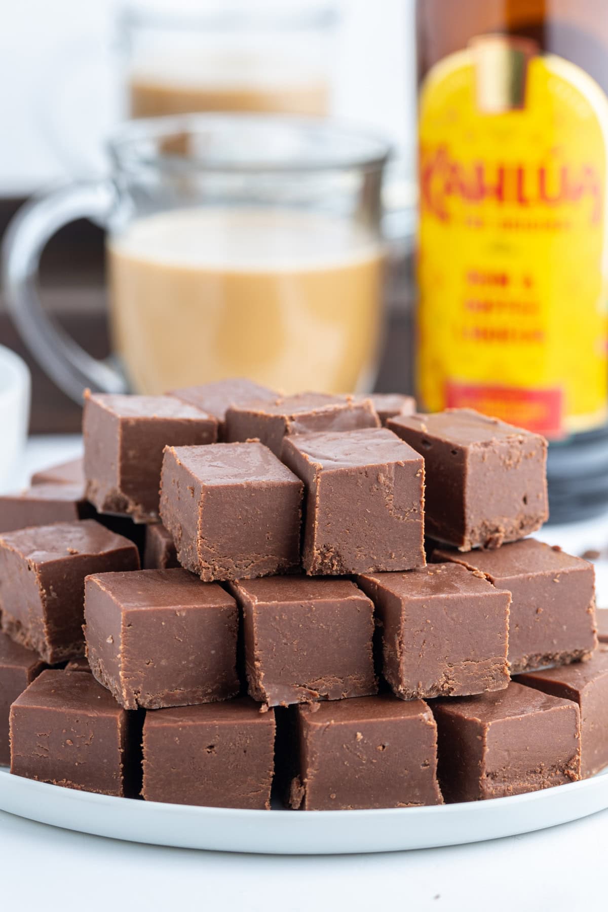 This Easy Microwave Kahlua Fudge has two chocolate layers, a rich Kahlua coffee flavor, and comes together in minutes. Perfect for holiday gifts and dessert trays! kahlua fudge stacked on a platter