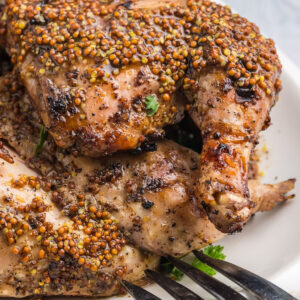grilled cornish game hens on a plate with honey mustard sauce