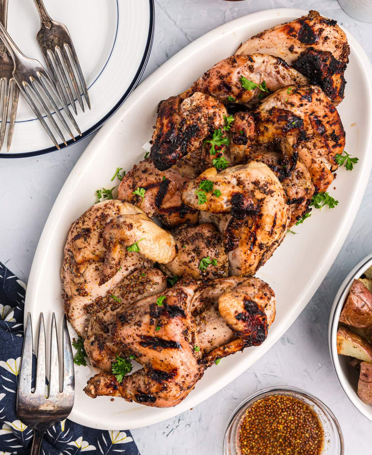 These Grilled Cornish Game Hens are brushed with a sweet-savory mustard glaze and grilled to juicy perfection—an impressive, easy main dish for holidays or entertaining. grilled cornish game hens on a platter