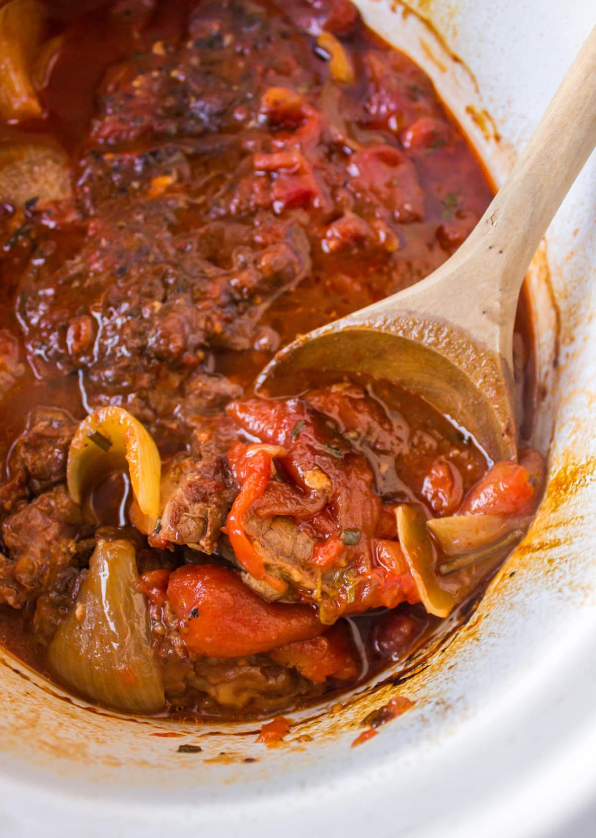 slow cooker italian pot roast in slow cooker insert with spoon