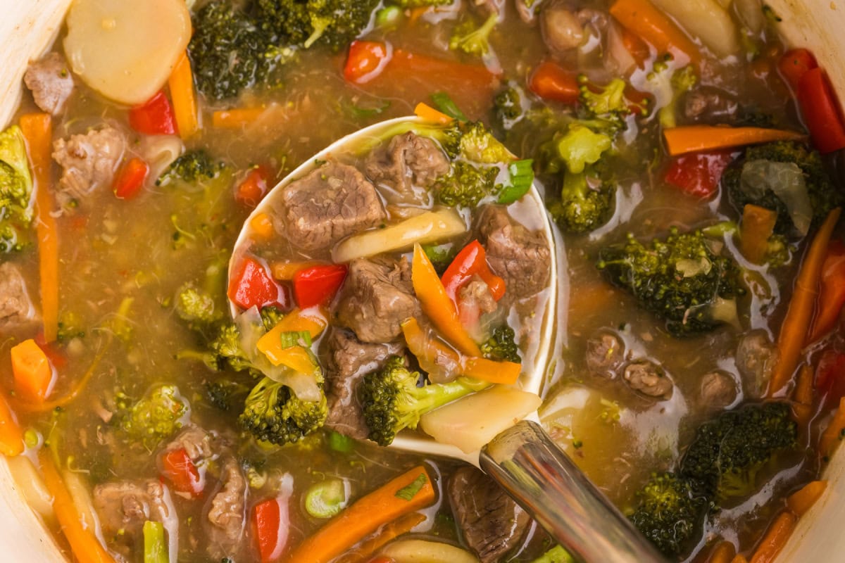 This Beef and Vegetable Stew is comfort food with a twist! Tender beef simmers in a savory soy-ginger broth with carrots, broccoli, red bell pepper, and water chestnuts. Perfect for cool nights and great for leftovers! ladle in beef and vegetable stew