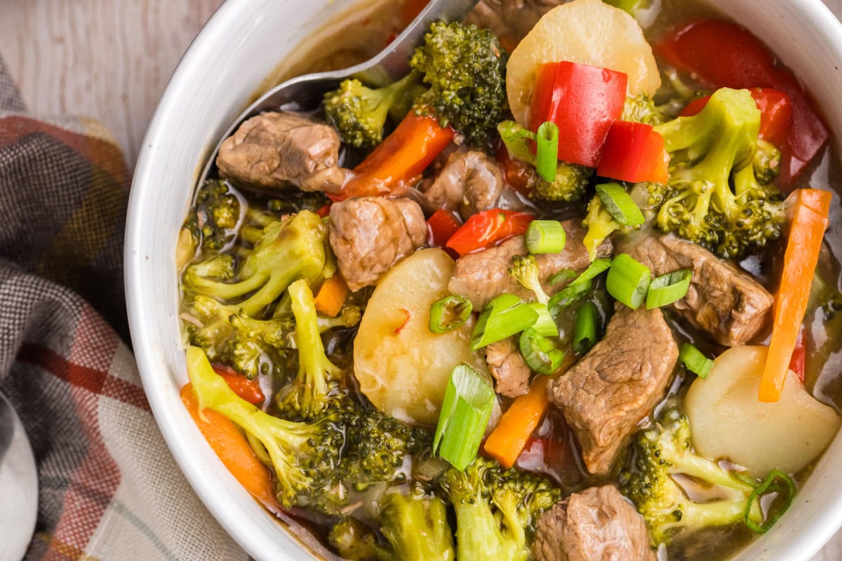 This Beef and Vegetable Stew is comfort food with a twist! Tender beef simmers in a savory soy-ginger broth with carrots, broccoli, red bell pepper, and water chestnuts. Perfect for cool nights and great for leftovers! bowl of beef and vegetable stew