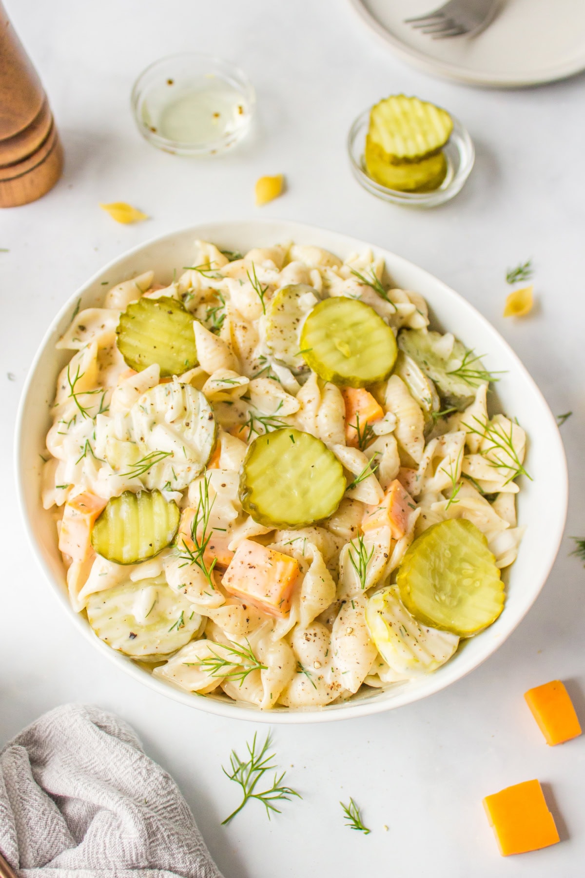 Dill Pickle Pasta Salad is the ultimate creamy, tangy side dish! Shell pasta is soaked in pickle juice, then tossed with cheddar, fresh dill, and a creamy dressing. Perfect for BBQs, potlucks, and summer parties! bowl of dill pickle pasta salad