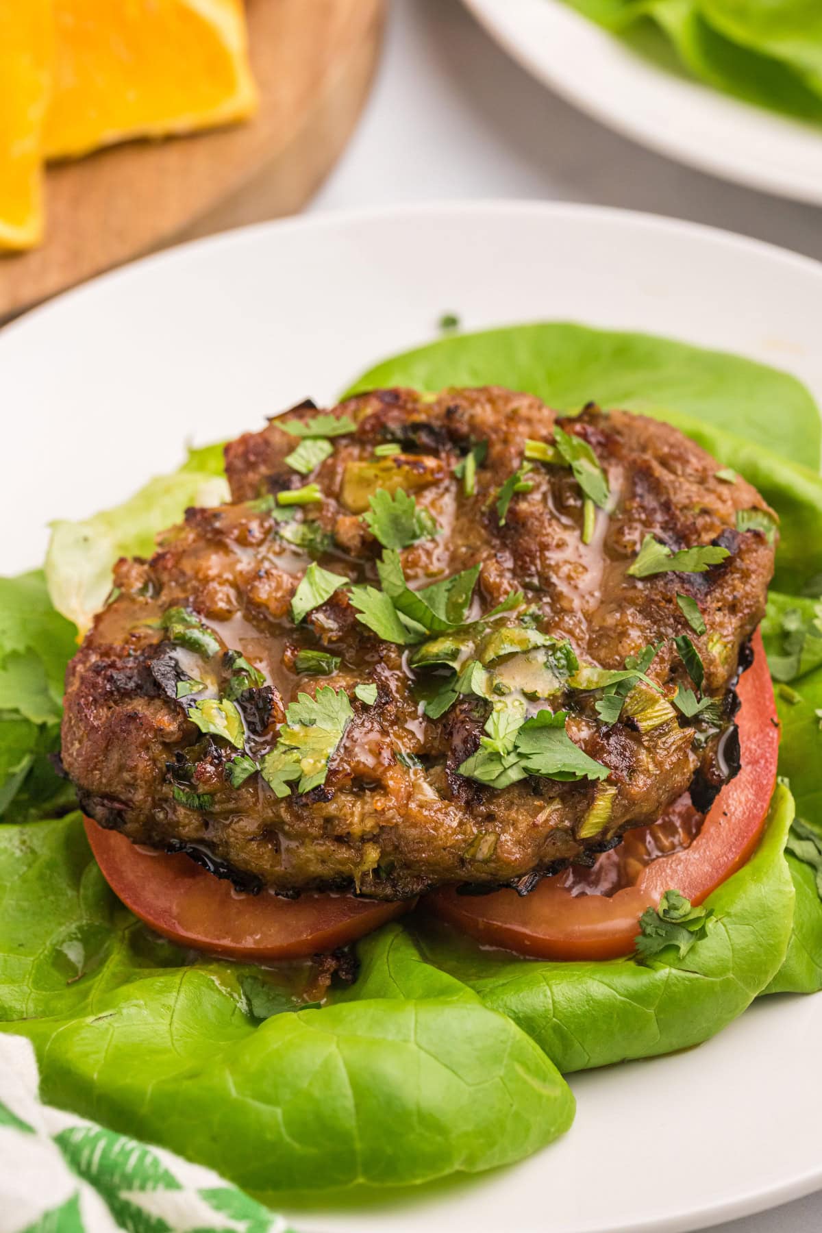 These Healthy Turkey Burgers with Orange Ginger Glaze are juicy, bright, and full of fresh flavor. Lean turkey meets a tangy homemade citrus glaze — perfect for easy dinners! healthy turkey burger pattie served over lettuce and tomato