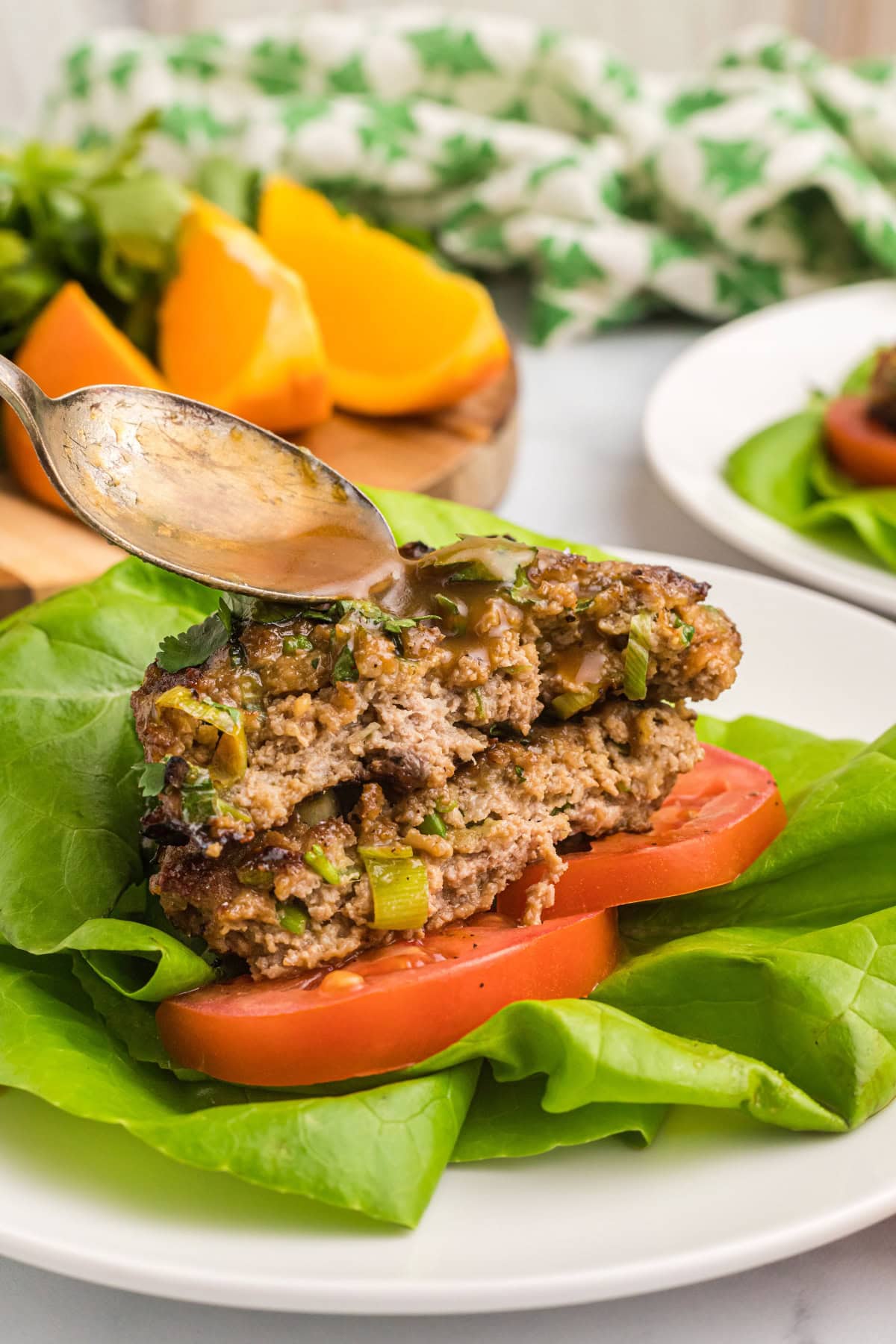 These Healthy Turkey Burgers with Orange Ginger Glaze are juicy, bright, and full of fresh flavor. Lean turkey meets a tangy homemade citrus glaze — perfect for easy dinners! healthy turkey burger pattie cut in half and stacked with sauce spooned over