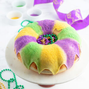 decorated king cake for mardi gras on a cake platter