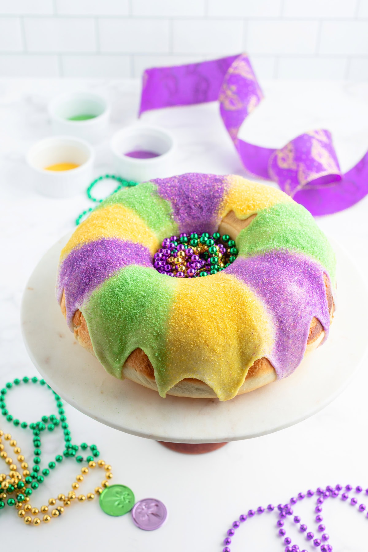 decorated king cake for mardi gras on a cake platter