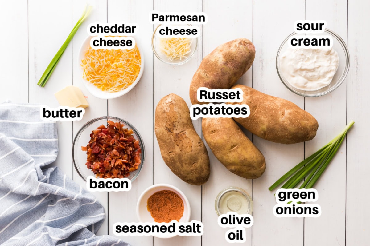 How to Make Potato Skins 🥔 Crispy baked potato shells brushed with buttery seasoning, filled with cheddar and bacon, then topped with sour cream and green onions. The BEST easy party appetizer! ingredients displayed for making potato skins appetizer