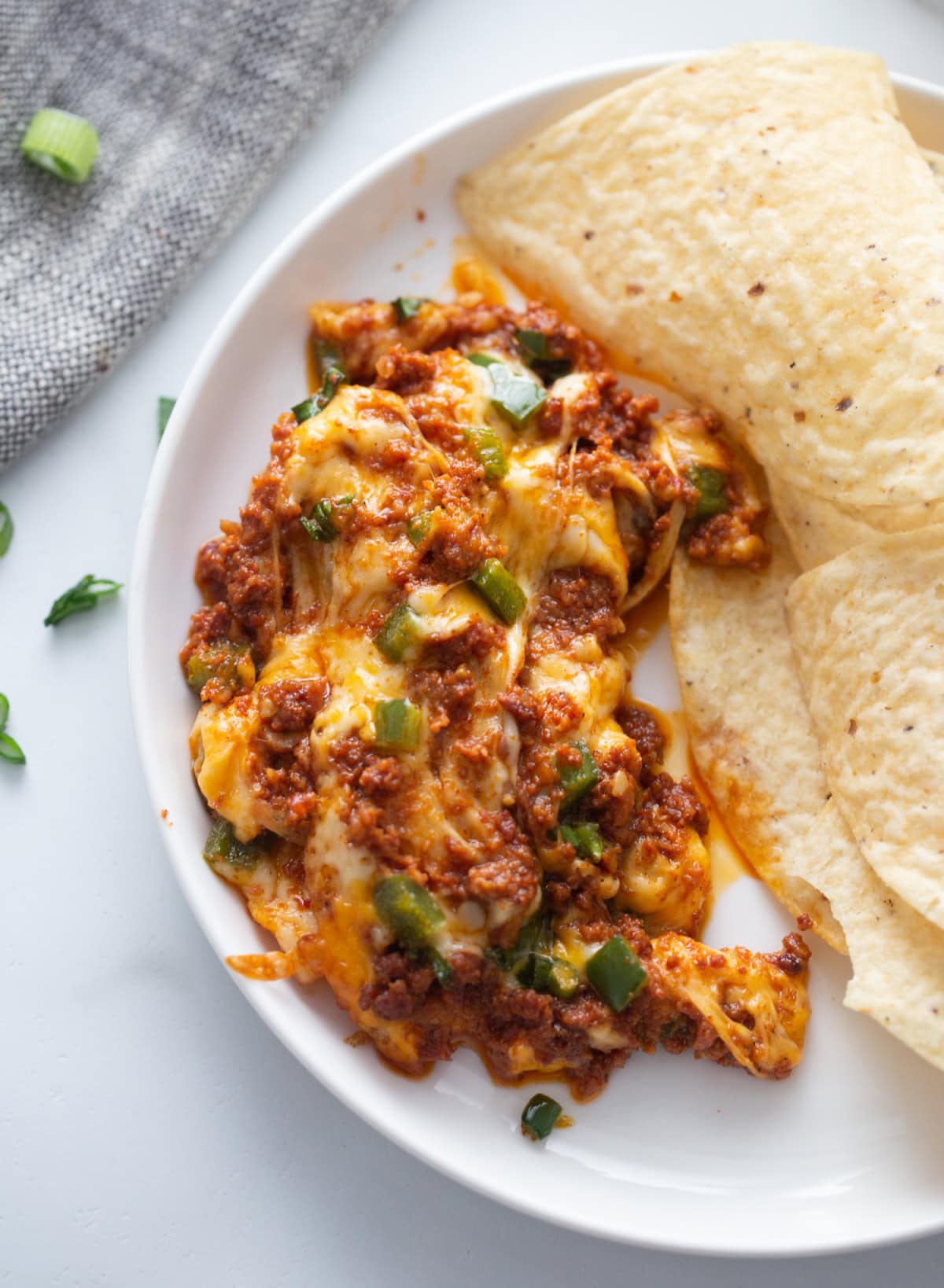 Queso Fundido Recipe 🧀🔥 Classic hot melted cheese dip baked with chorizo, jalapeños, and green onions. Ready in 30 minutes and perfect for parties, taco night, and game day! serving of queso fundido on plate with chips