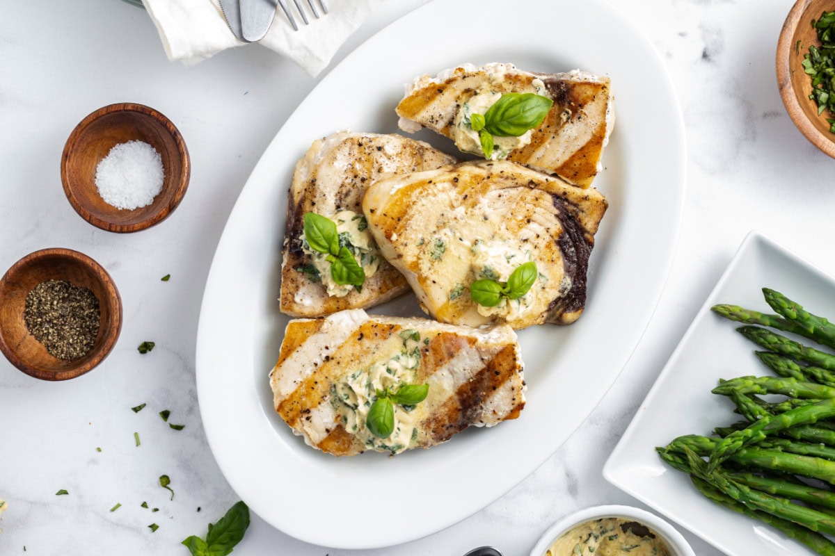 overhead grilled swordfish steaks on plate with mustard basil butter