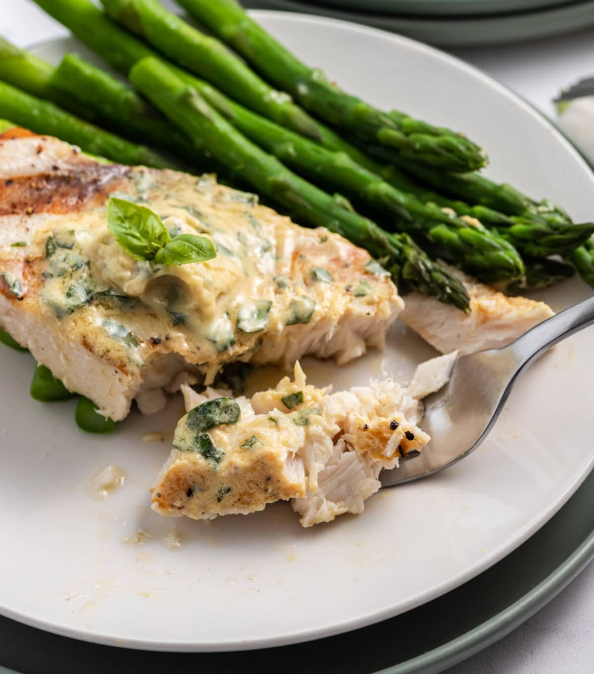 grilled swordfish with mustard basil butter cut open with fork