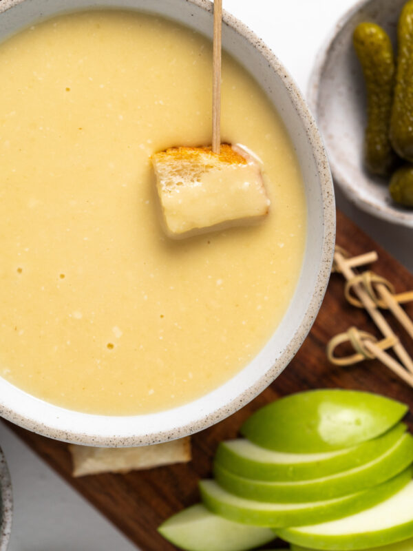 toothpick with bread in bowl of cheese fondue