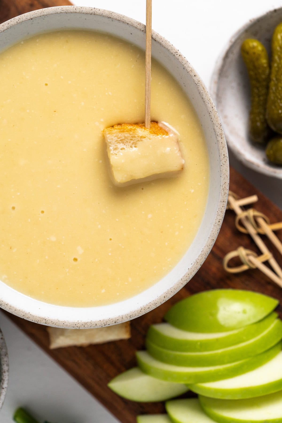 toothpick with bread in bowl of cheese fondue