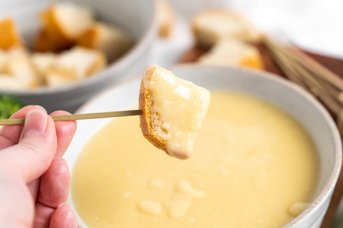 dipping bread cube into cheese fondue