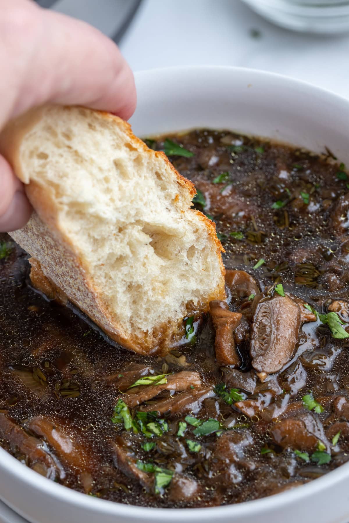 dunking bread into bowl of mushroom soup