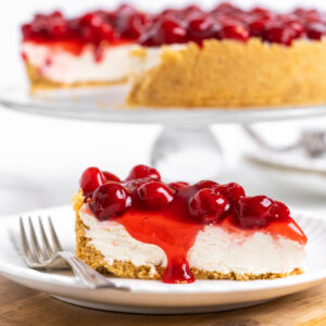 slice of no bake cherry cheesecake on plate with fork