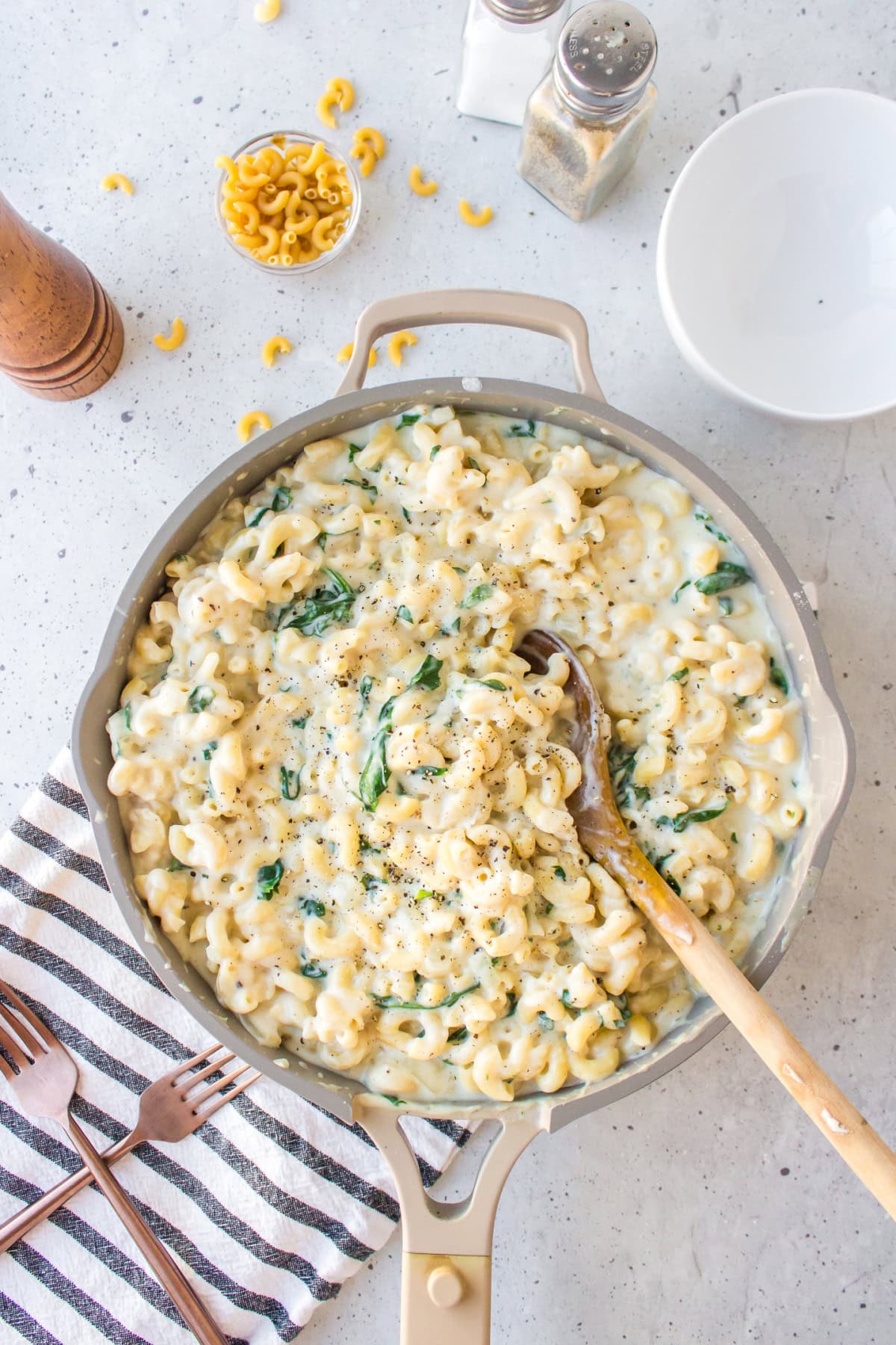 Spinach Mac and Cheese is creamy, cheesy comfort food with fresh spinach and a blend of delicious cheeses. overhead shot of skillet full of spinach mac and cheese
