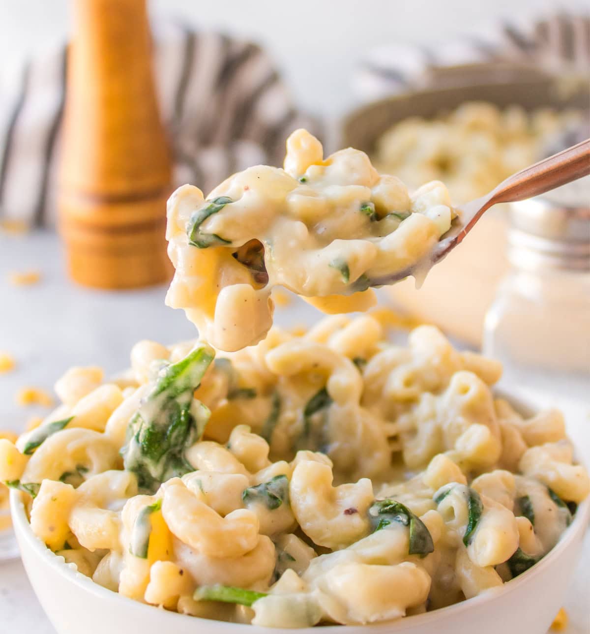 Spinach Mac and Cheese is creamy, cheesy comfort food with fresh spinach and a blend of delicious cheeses. fork full of spinach mac and cheese