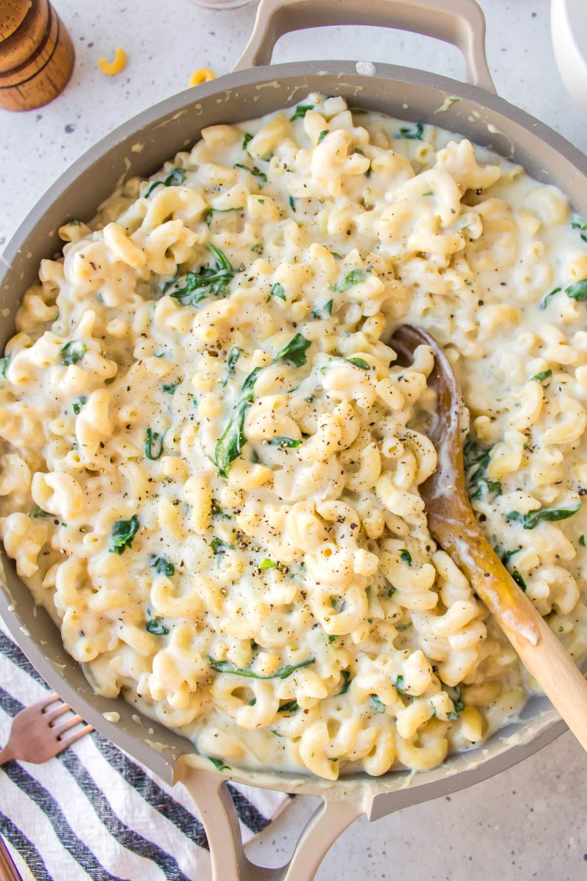 Spinach Mac and Cheese is creamy, cheesy comfort food with fresh spinach and a blend of delicious cheeses. spinach mac and cheese in skillet