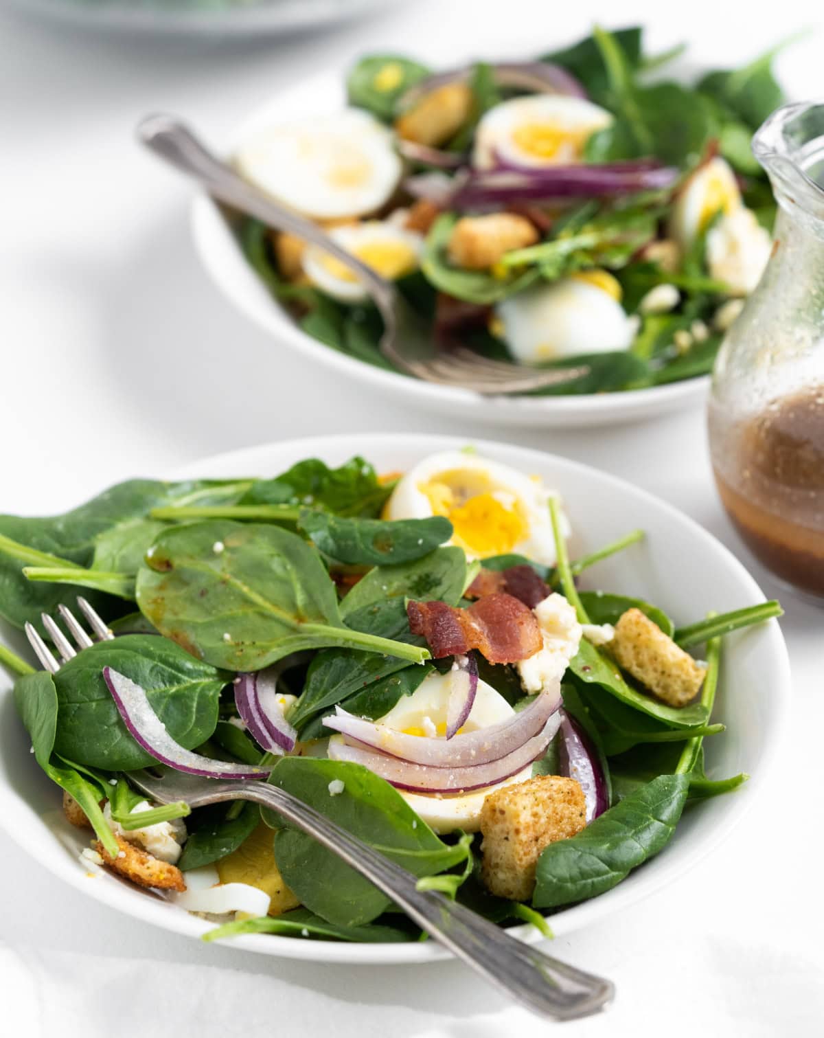 servings of baby spinach salad on plates