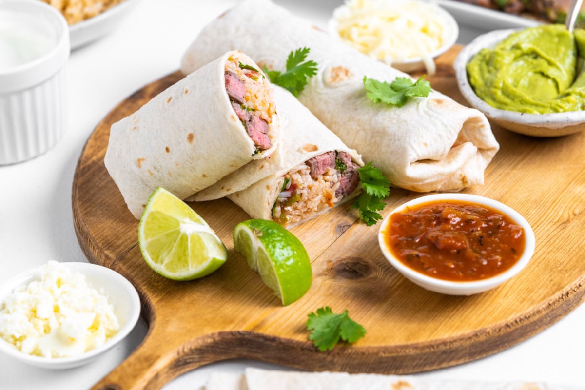 carne asada burritos displayed with one cut in half