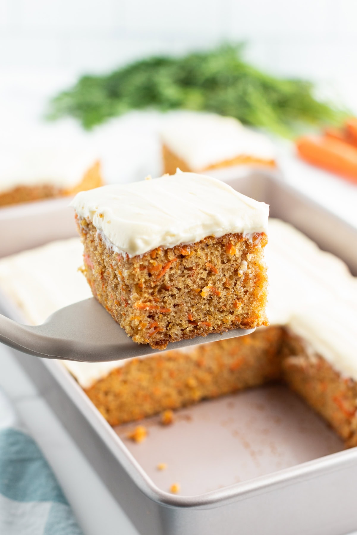 spatula holding slice of carrot cake sheet cake