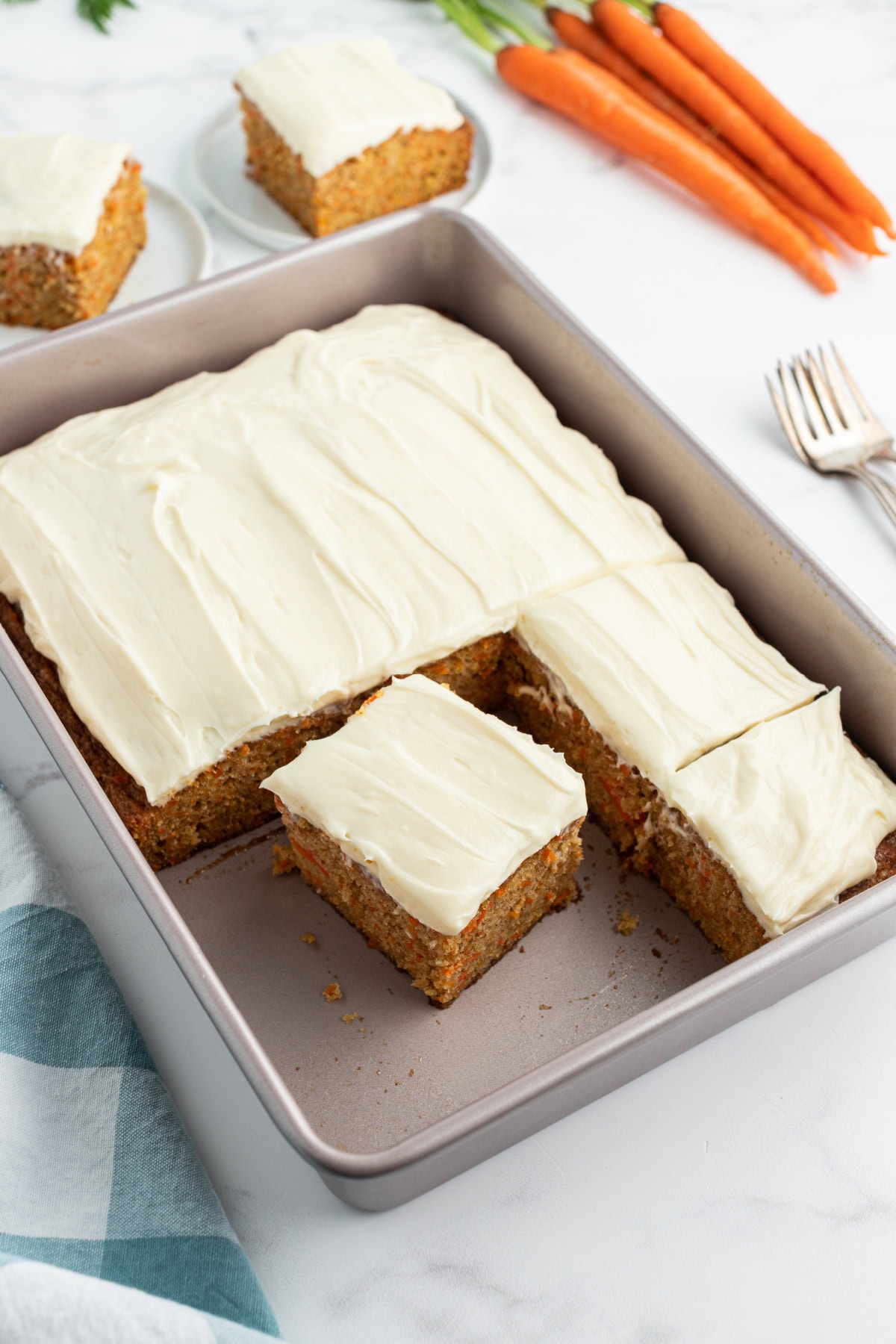 carrot cake sheet cake with slices cut out of it