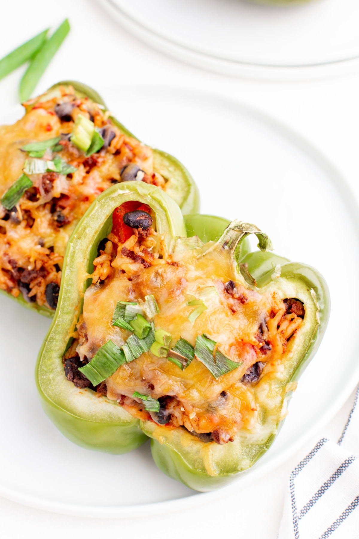 Taco Stuffed Peppers are packed with seasoned beef, rice, beans and cheese. A healthy and delicious twist on taco night! serving of taco stuffed peppers on a plate