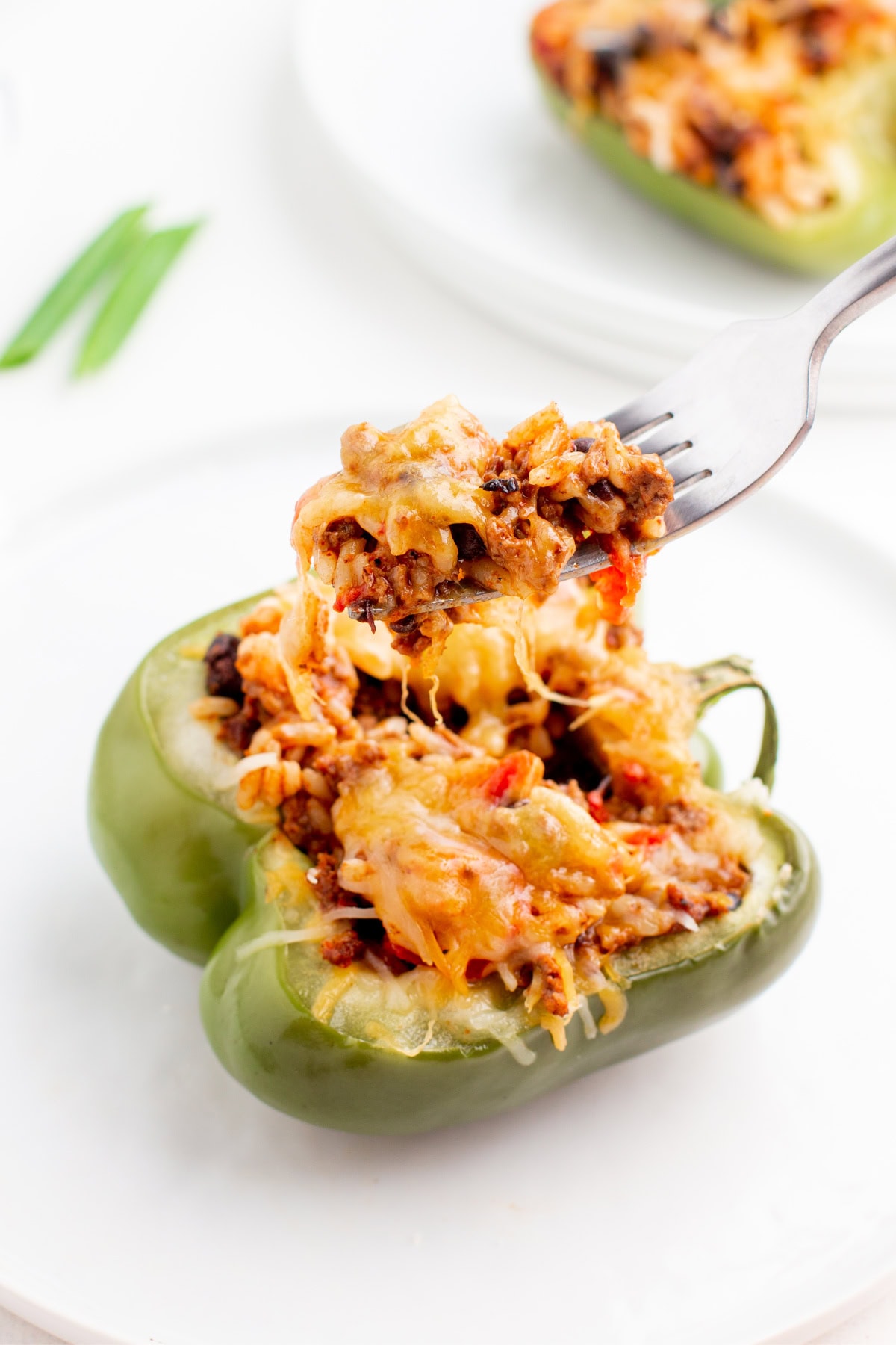 Taco Stuffed Peppers are packed with seasoned beef, rice, beans and cheese. A healthy and delicious twist on taco night! fork full of taco stuffed peppers
