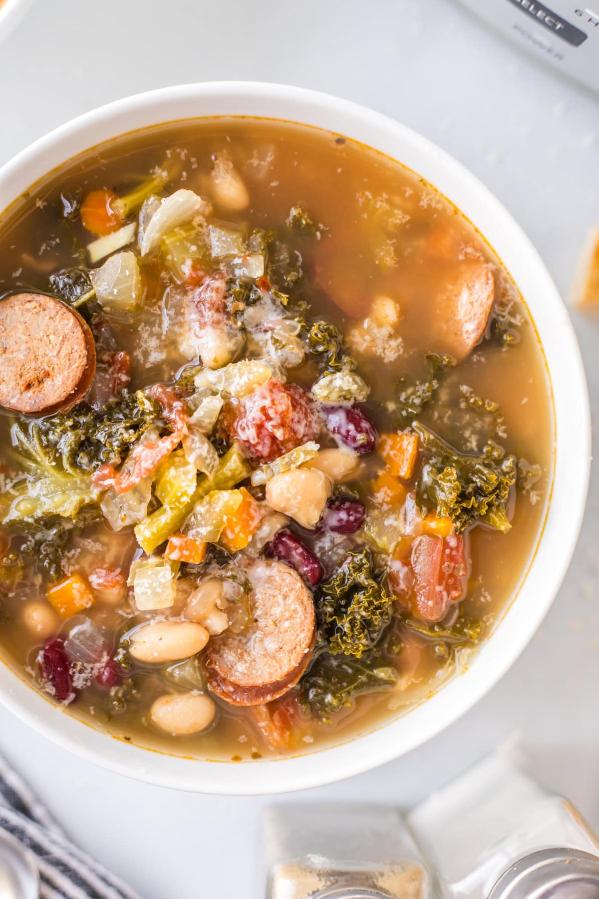 tuscan sausage soup in a white bowl