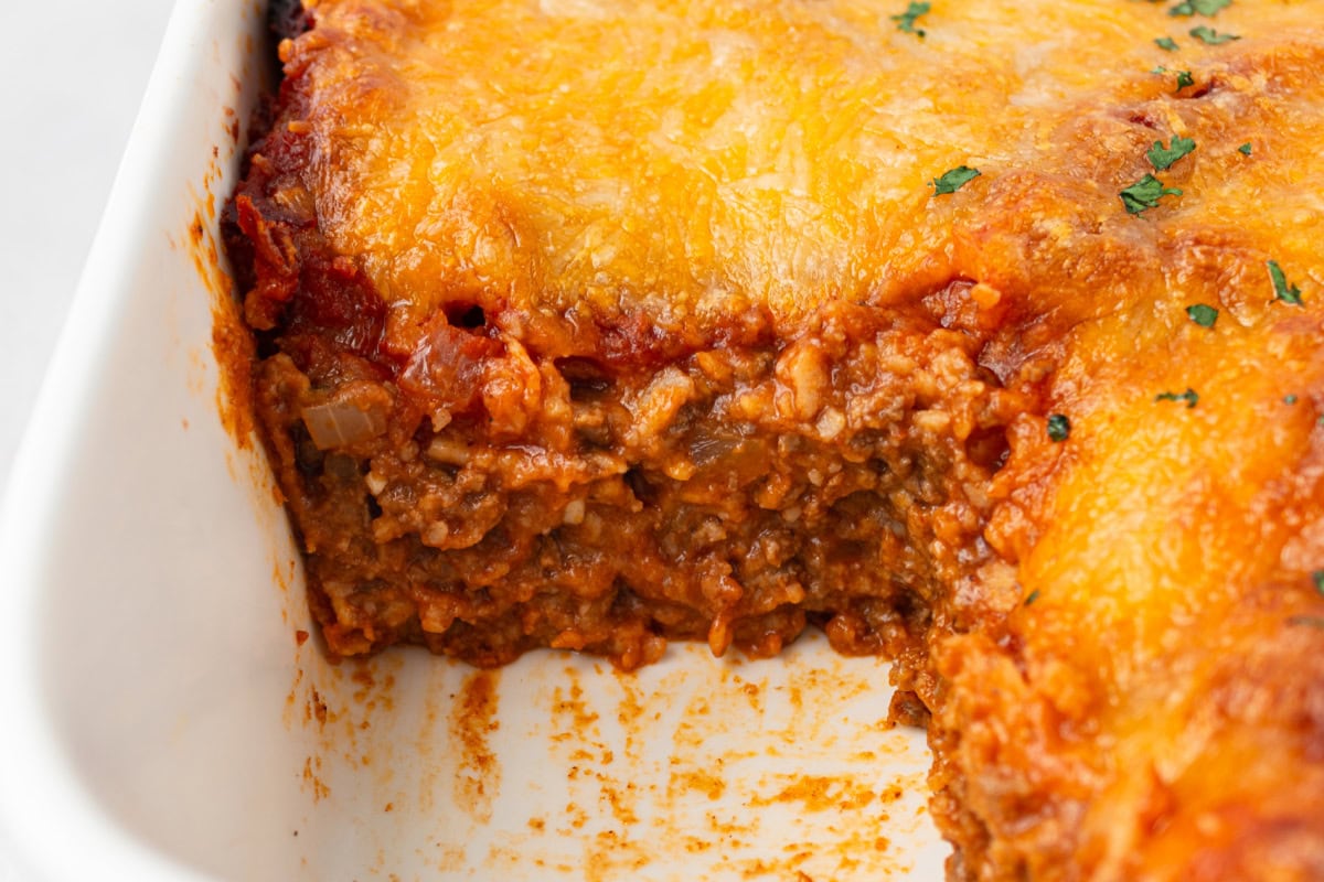 beef enchilada bake in pan with slice taken out