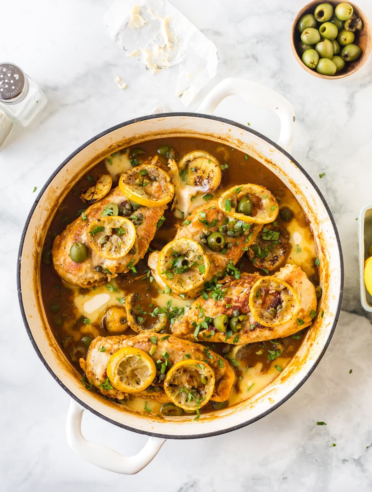 skillet full of chicken with roasted lemons