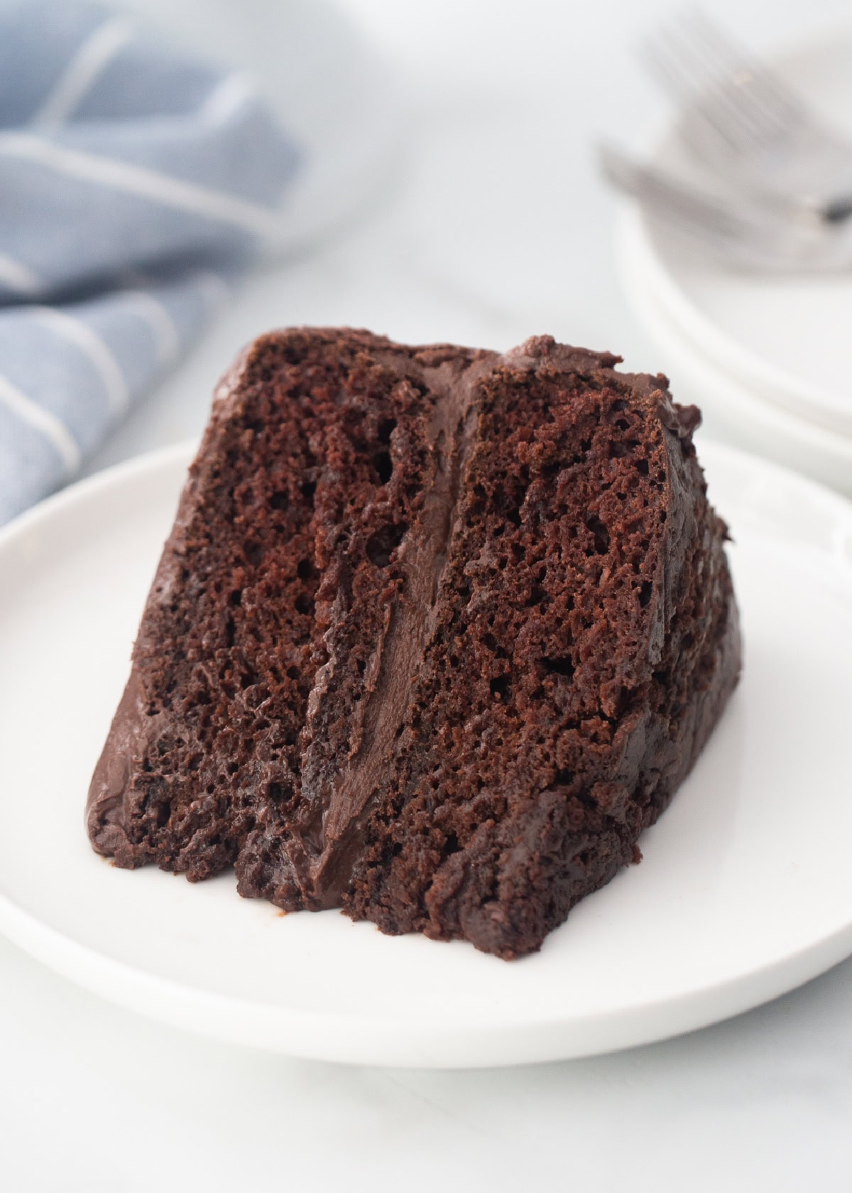 Chocolate Mayonnaise Cake is rich, moist and incredibly easy to make. The secret ingredient makes this cake unbelievably soft and delicious. slice of chocolate cake on plate