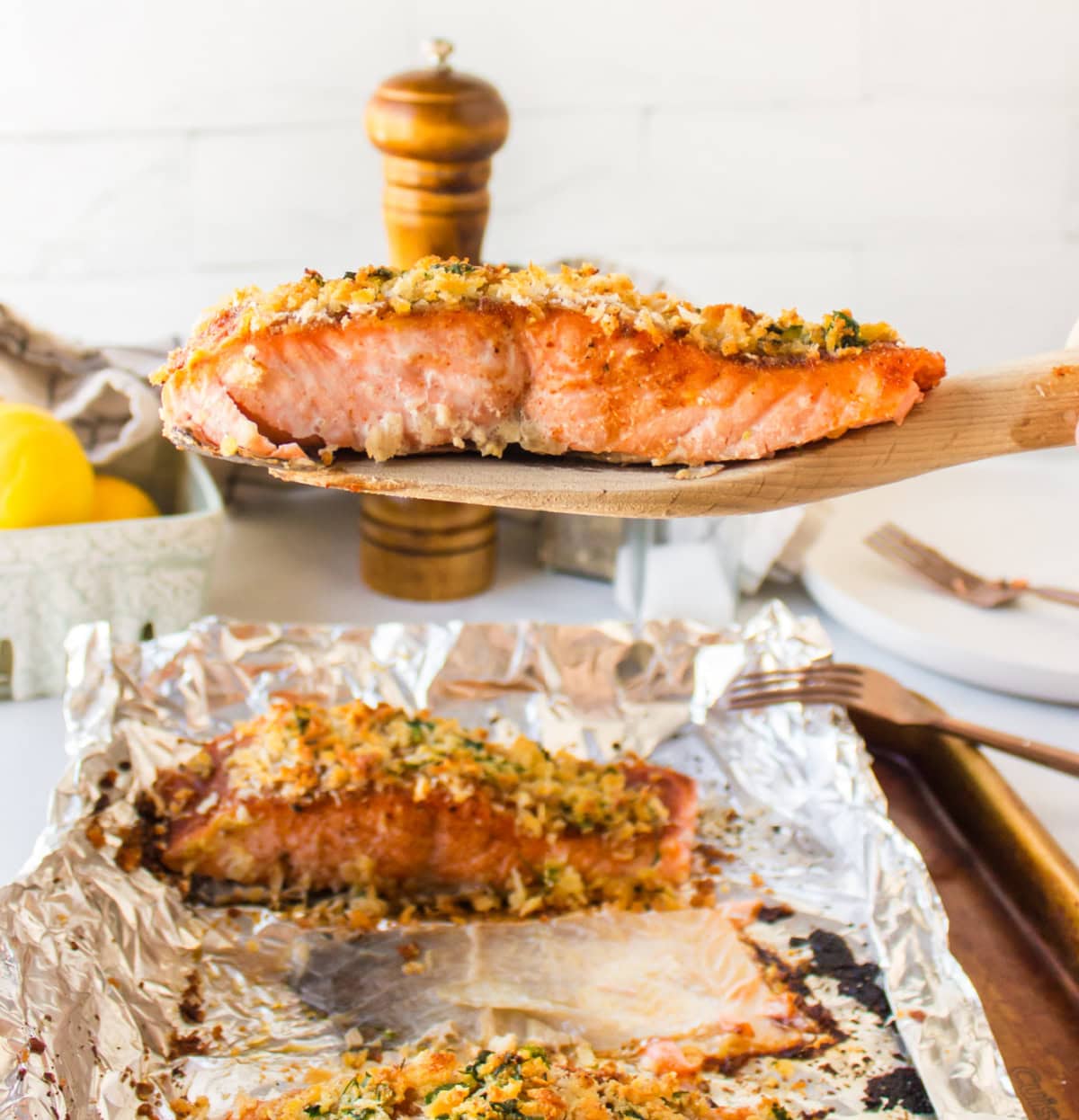 Easy Baked Salmon with a crispy breadcrumb topping and sweet savory flavor. A quick and delicious salmon dinner ready in minutes. spatula holding a piece of easy baked salmon