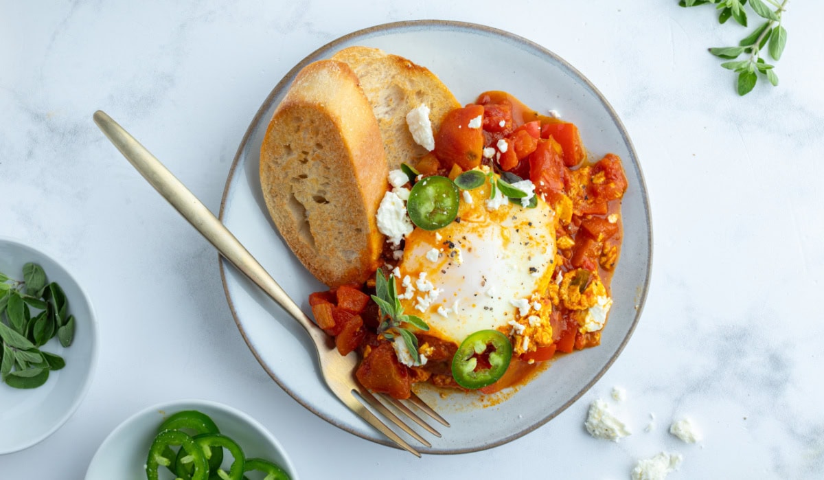 serving of shakshuka on plate with bread