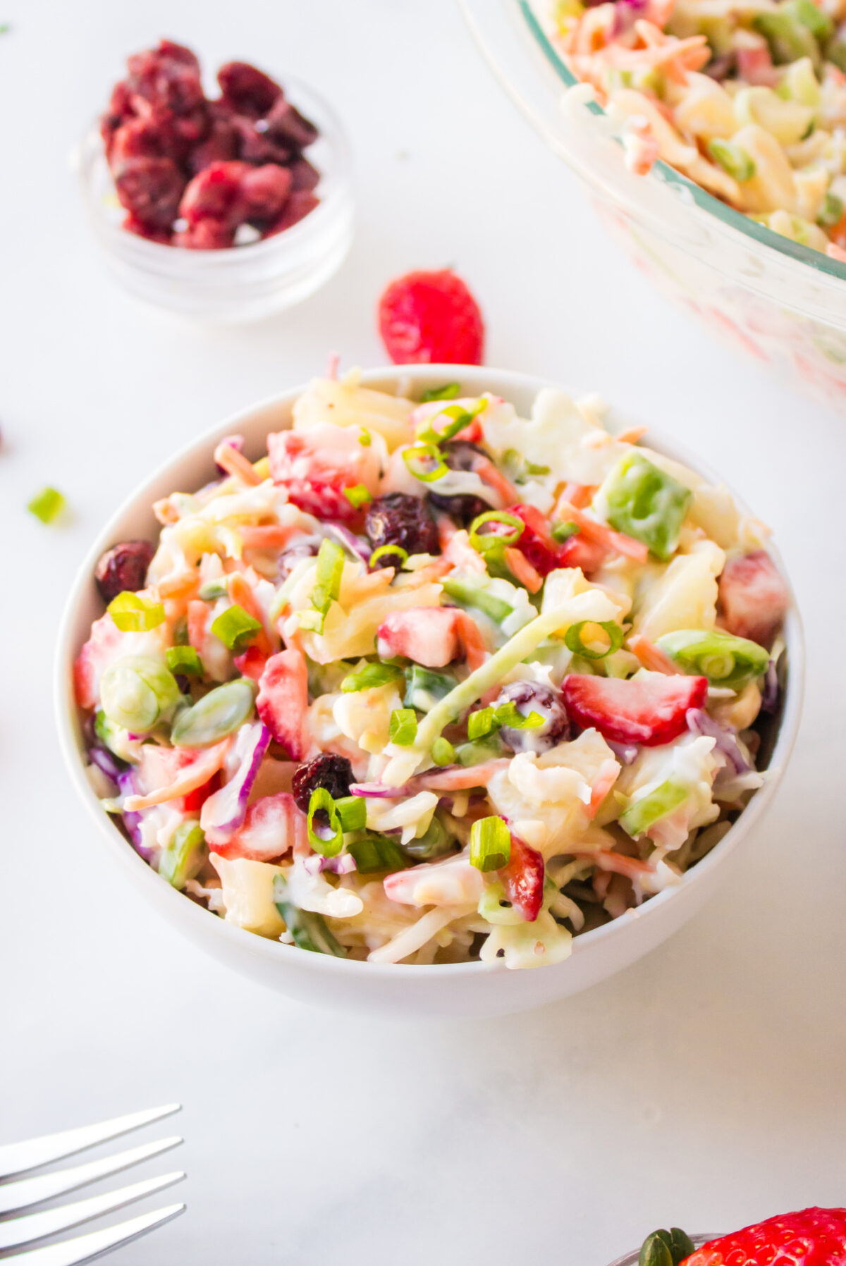 Fruity Coleslaw with strawberries, pineapple and coconut is a sweet, tangy and crunchy side dish perfect for BBQs and summer gatherings. serving of fruity coleslaw in bowl
