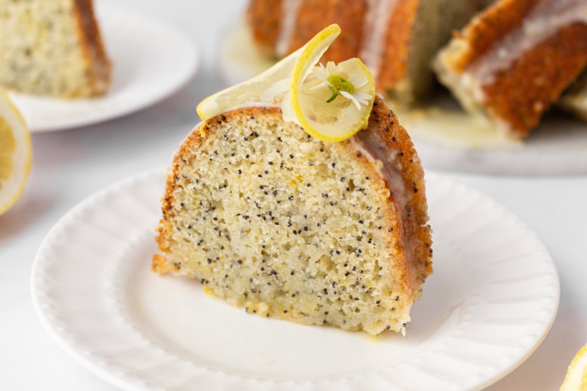 Lemon Poppy Seed Cake is soft, moist and packed with fresh lemon flavor. A bright and delicious dessert perfect for any time of year. slice of lemon poppy seed cake on a plate