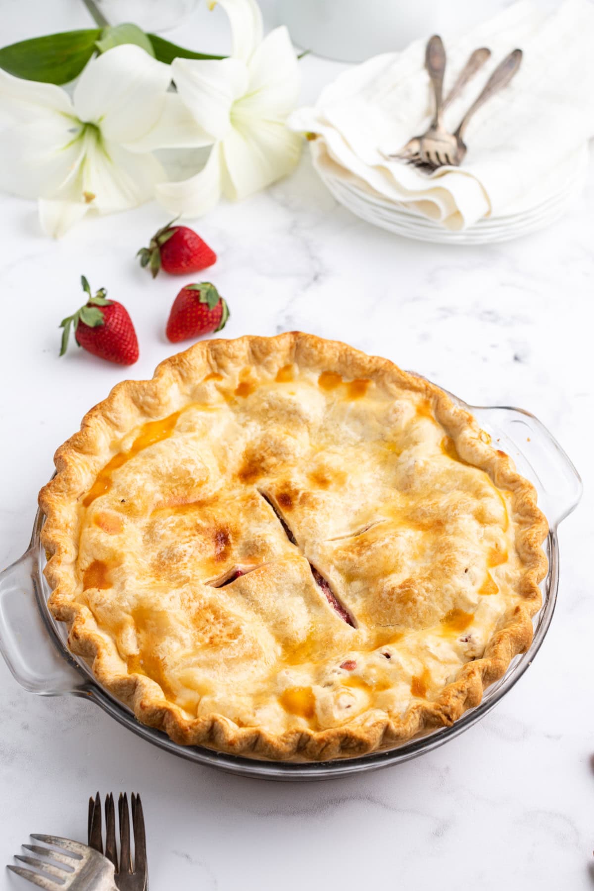 Delicious homemade strawberry rhubarb pie with golden crust and fresh fruit filling. Perfect dessert.
