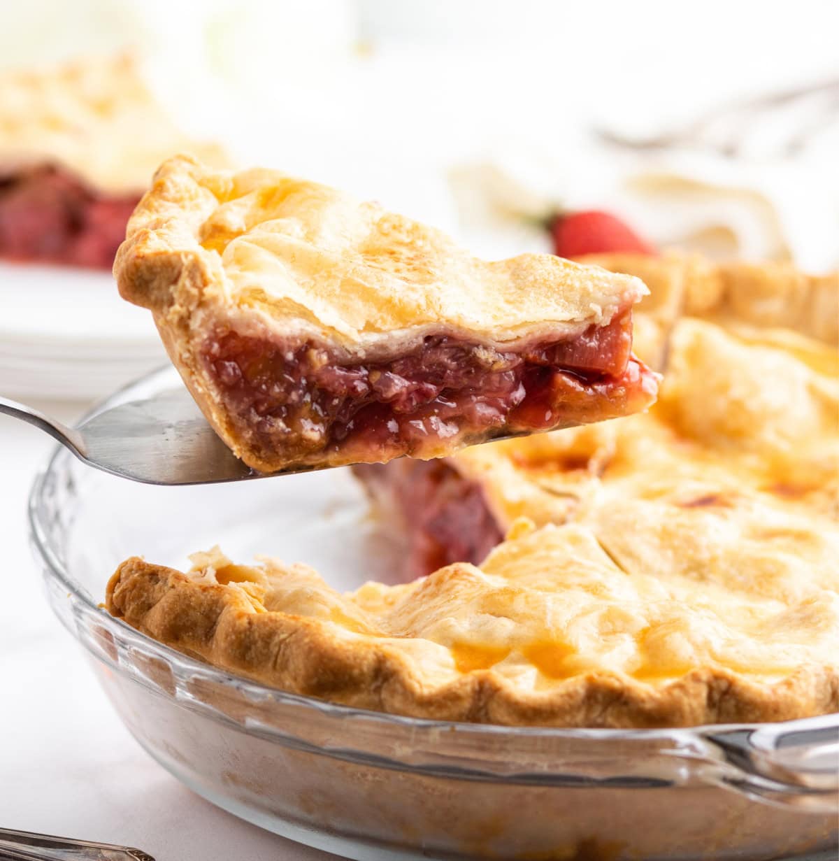 spatula picking up slice of strawberry rhubarb pie