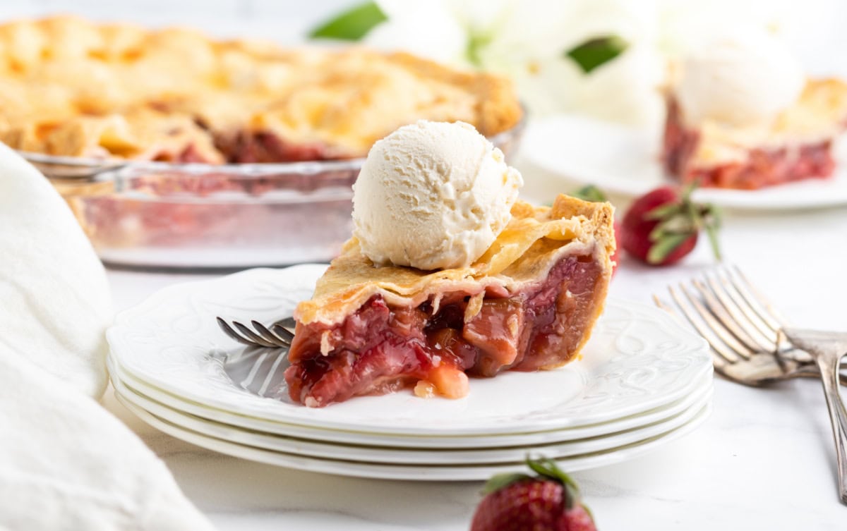 Strawberry Rhubarb Pie with a sweet-tart filling and flaky crust. A classic fruit pie that’s perfectly balanced and so delicious! ice cream topped strawberry rhubarb pie